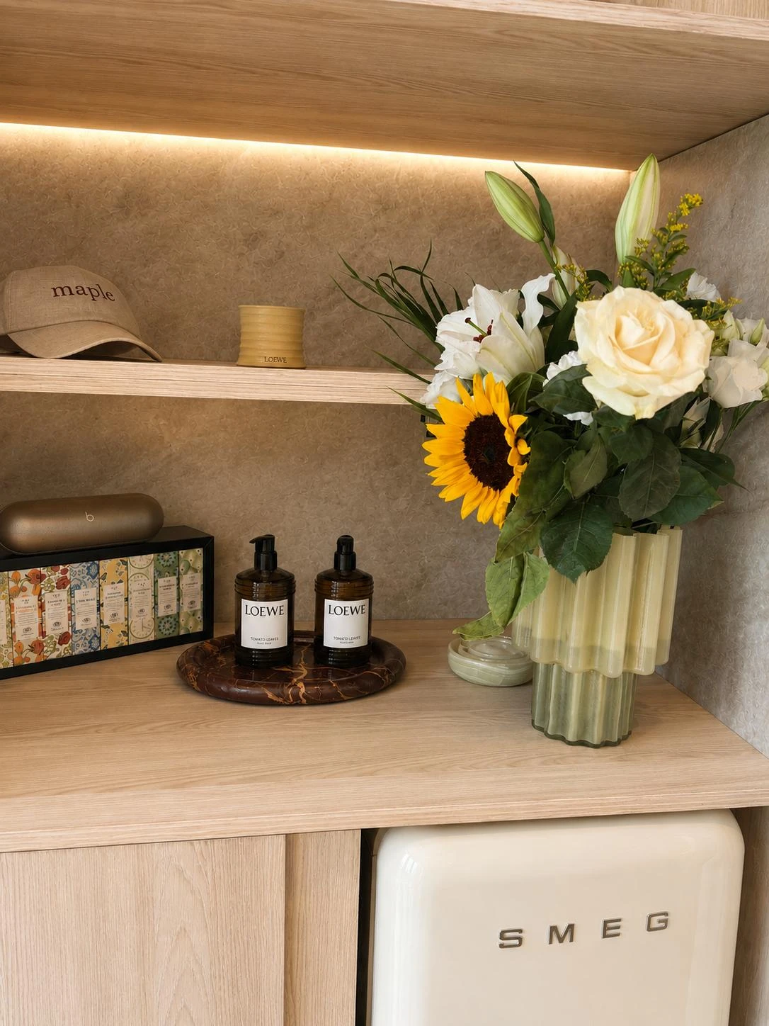 Luxury spa decor details including Loewe candle and fresh flowers at Maple Head Spa